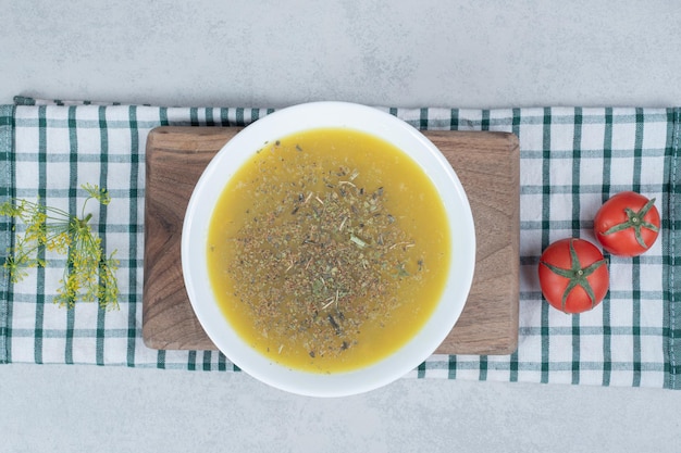 Heerlijke soep met greens en twee tomaten op tafelkleed