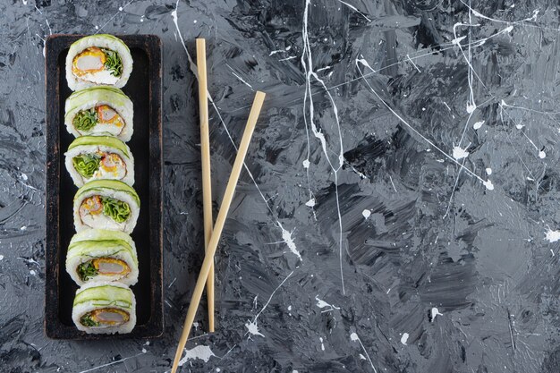 Heerlijke sushi rolt met tonijn op stenen tafel.