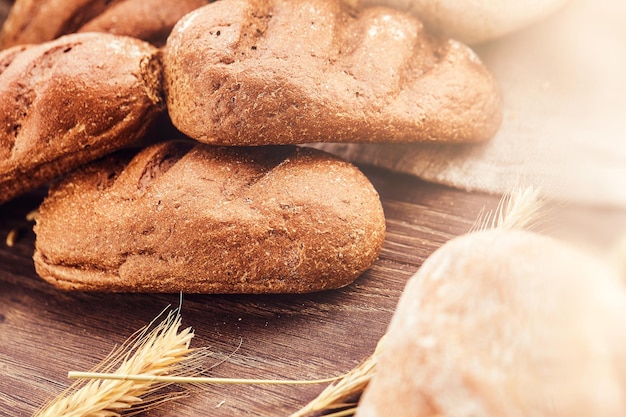 Gratis foto heerlijke vers bakkerijproducten op houten achtergrond. close-up foto van een vers gebakken broodproducten.