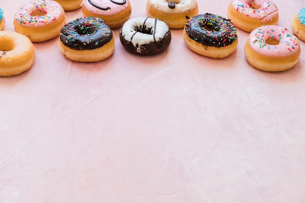 Gratis foto heerlijke verse donuts op roze achtergrond