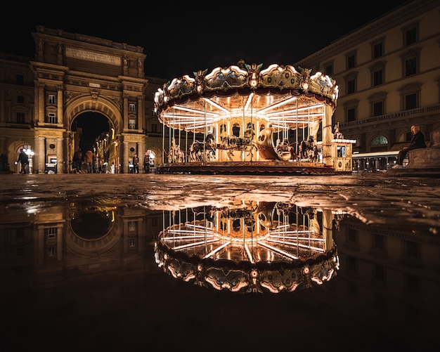 Gratis foto heldere carrousel met reflectie 's nachts