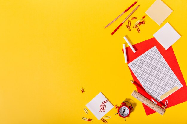 Heldere set schoolspullen bestaande uit rood en papier, clips, kleurpotloden, potloden en houten liniaal