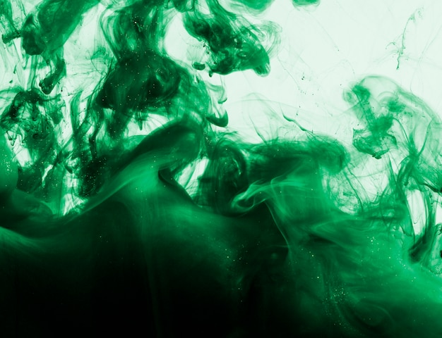Heldergroene wolk van pigment in vloeistof