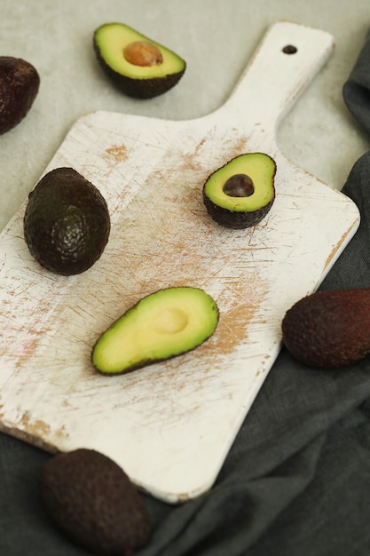 Gratis foto hele en gesneden avocado's op houten snijplank