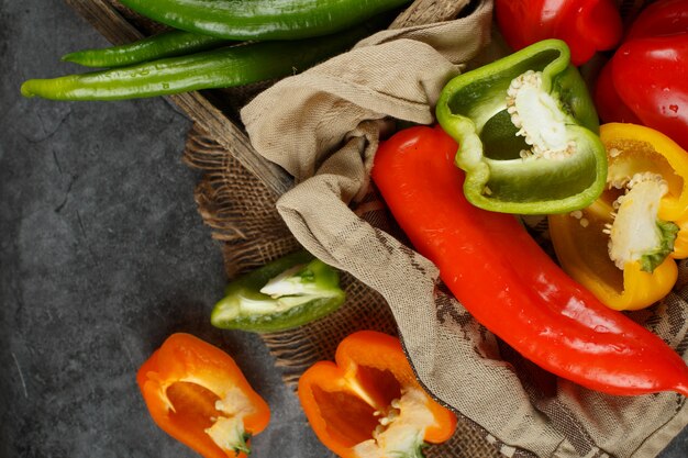 Hele en halve paprika's in een rustieke lade. Bovenaanzicht