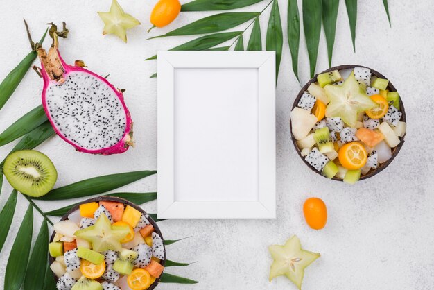Helften van kokos gevuld met fruitsalade en frame