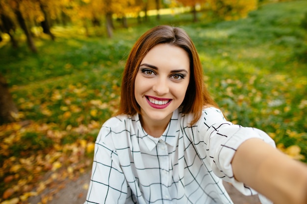 Gratis foto herfst selfie portret van een gourgeus opgewonden meisje.