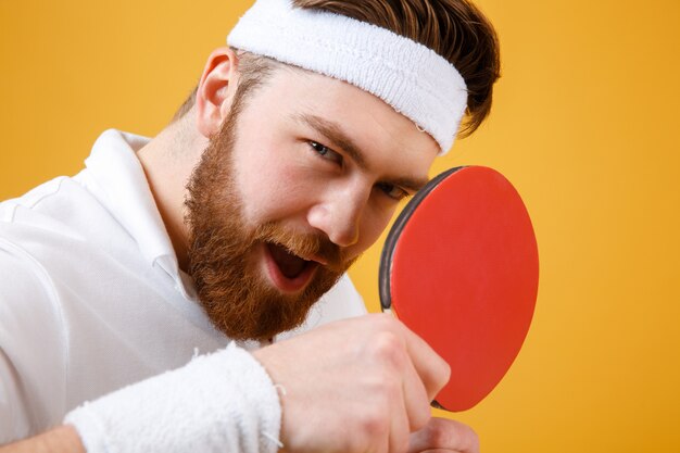 Het aantrekkelijke jonge racket van de sportmanholding voor pingpong.