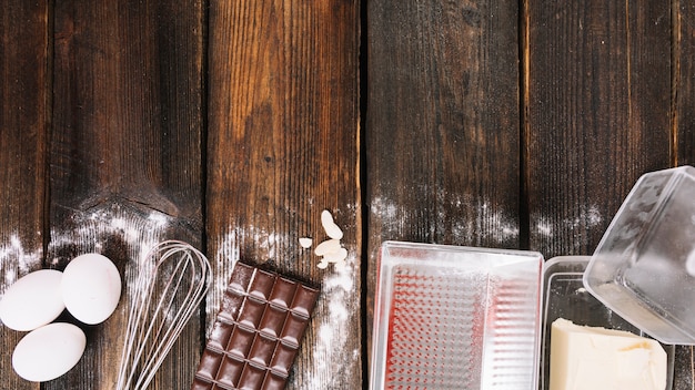 Het bakken van een cakeingrediënten met keukenwerktuig op houten plank