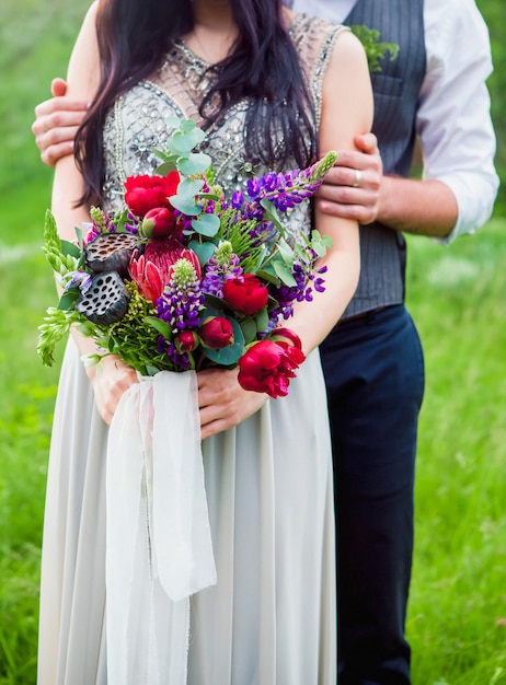Het bijsnijdbeeld van romantisch paar met bloemen