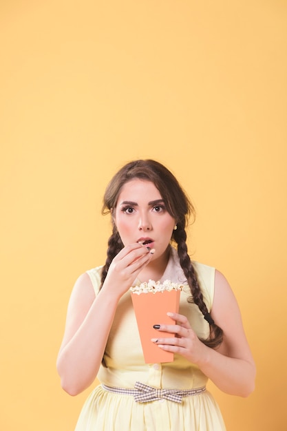 Het boeiende vrouw stellen met popcorn