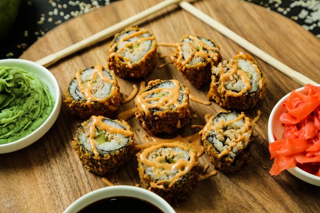 Het broodje van sushi dat op het bureau wordt geplaatst dat met saus hoogste mening wordt bedekt