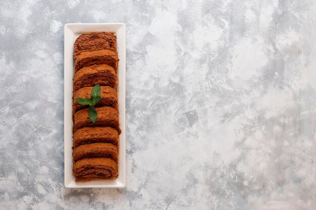 Het cakebroodje van de chocolade met cacaopoeder op witte plaat, hoogste mening