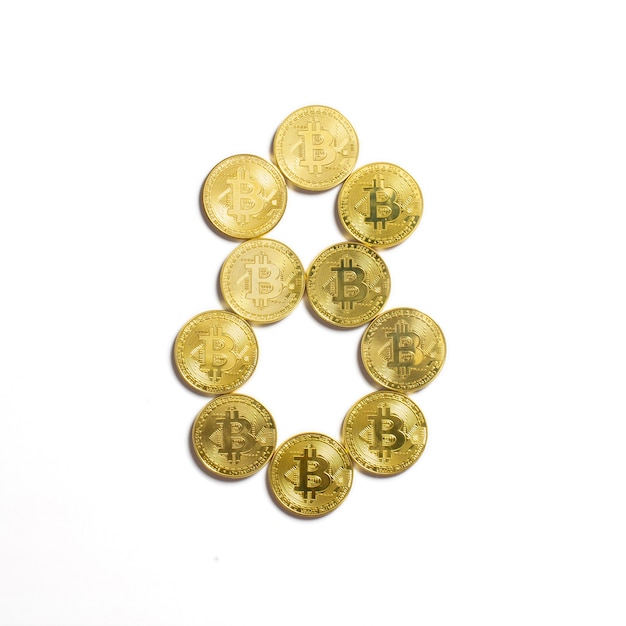 Gratis foto het cijfer van 8 opgemaakt uit bitcoin munten en geïsoleerd op een witte achtergrond