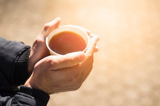 Het close-up van man handholding haalt koffiekop weg