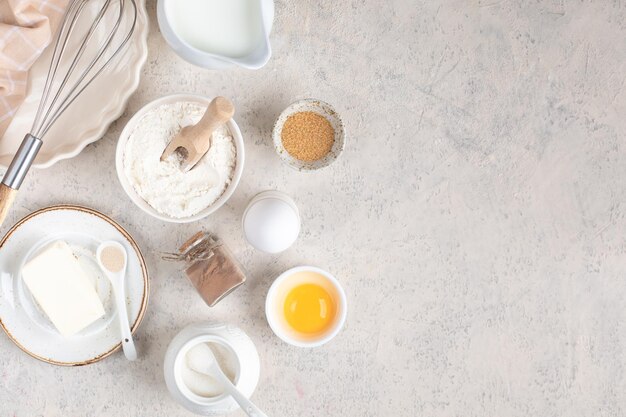 Het concept van thuisbakken Ingrediënten voor het maken van deeg cake cupcakes eieren meel boter kaneel melk suiker op een lichte achtergrond