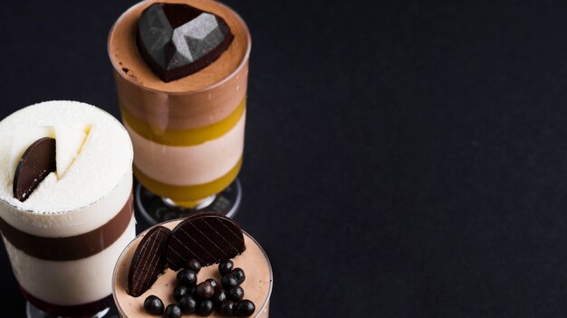Het dessert van de chocoladeroom met bovenste laagjes in het glas op zwarte achtergrond