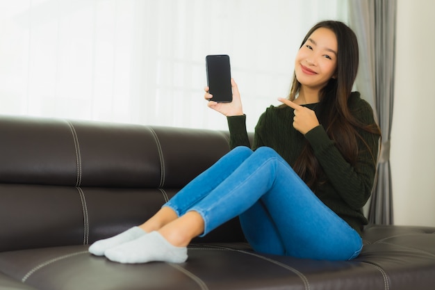 Het gebruik slimme mobiele telefoon van de portret mooie jonge Aziatische vrouw