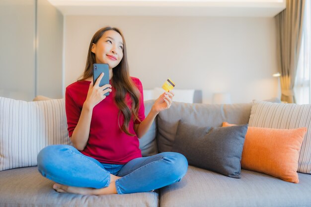 Het gebruik van de portret mooie jonge Aziatische vrouw slimme mobiele telefoon met creditcard