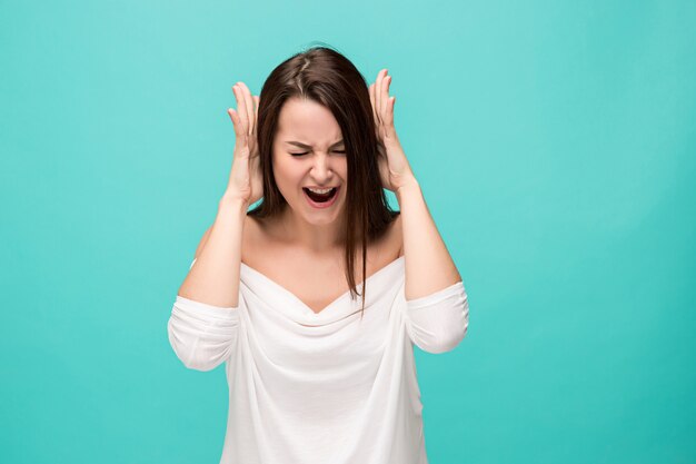 Het gefrustreerde jonge vrouw stellen op blauw