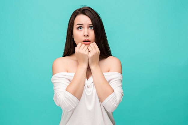 Het gefrustreerde jonge vrouw stellen op blauw