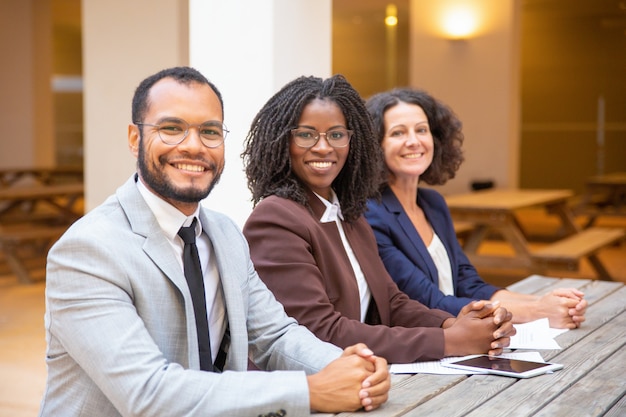 Gratis foto het gelukkige diverse commerciële team stellen in straatkoffie