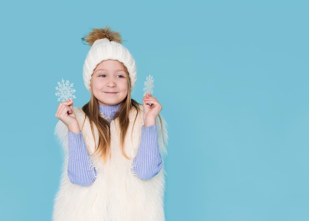 Gratis foto het gelukkige meisje spelen met sneeuwvlokken