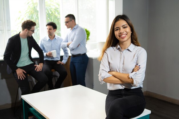 Het gelukkige mooie manager stellen in bureauwerkruimte