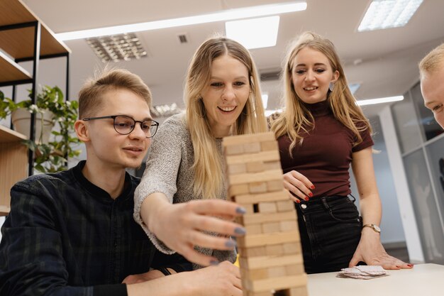 Het gemengde team spelen blokkeert houten spel in het bureau