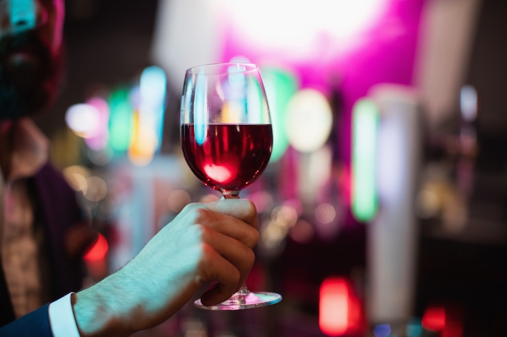 Gratis Foto het glas van de zakenmanholding wijn