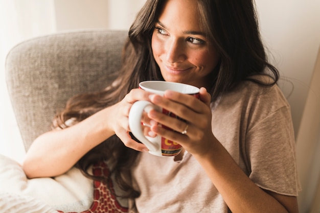 Het glimlachen van de koffiemok van de tienerholding