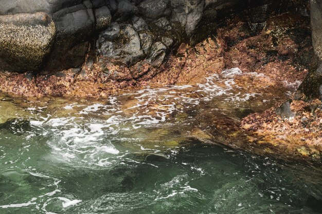 Het golvende water van de close-up bij rotsachtige kust