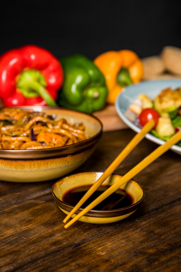 Gratis Foto het hakken van stokken over de kom met sojasaus met thais traditioneel eten op een houten bureau