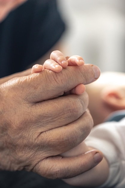 Gratis foto het handvat van een pasgeborene in de handen van een grootmoederclose-up