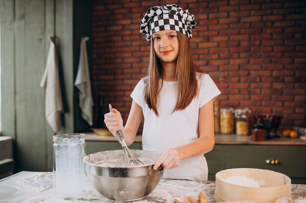 Het jonge gebakje van het meisjebaksel bij de keuken voor ontbijt