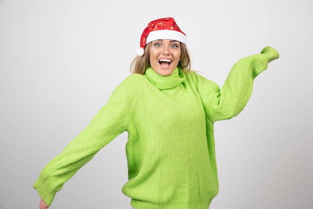 Het jonge mooie vrouw stellen in de rode hoed van de Kerstman.