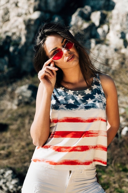 Gratis foto het jonge vrouw stellen in amerikaanse vlagt-shirt