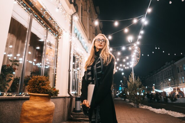 Het jonge vrouw stellen met laptop op de straat