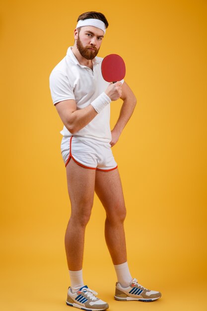 Het knappe jonge racket van de sportmanholding voor pingpong