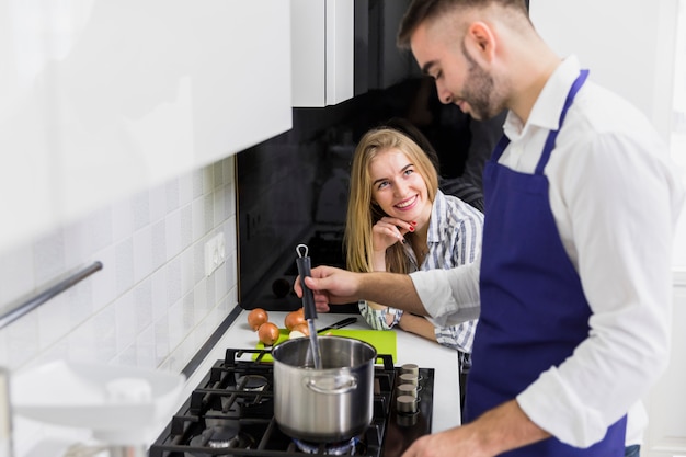 Het kokende water van de mens in pot op fornuis