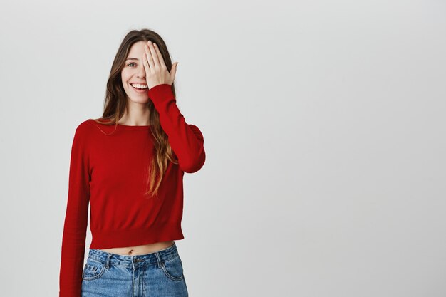 Het leuke meisje dat haar gezichtsopticiens controleert, behandelt één oog en het glimlachen