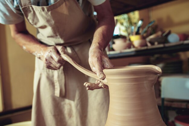 Het maken van een pot of vaas van witte klei close-up.