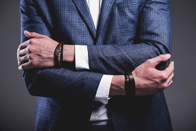 Het manierportret van de jonge zakenman knappe modelmens kleedde zich in elegant blauw kostuum op grijs.