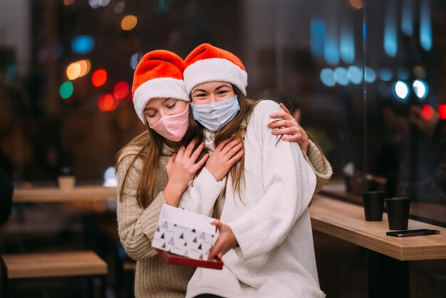 Het meisje geeft een geschenk aan haar vriendin in cafe