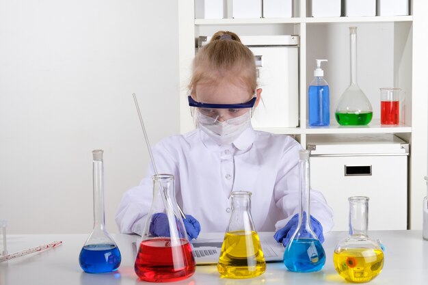 Het meisje houdt zich bezig met chemie in het laboratorium