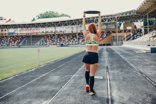 Gratis foto het meisje in het stadion is aan het sporten