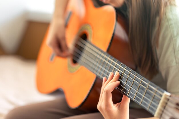 Het meisje speelt klassieke of akoestische gitaar Gitaar close-up