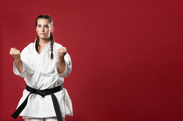 Het meisje van de vechtsportenkarate met zwarte band en exemplaar ruimteachtergrond