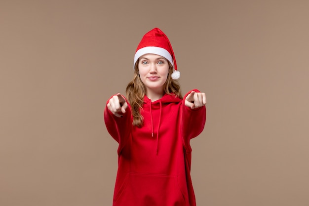 Het meisje van vooraanzichtkerstmis met het glimlachen gezicht op bruine achtergrondvakantie nieuwe jaar Kerstmis