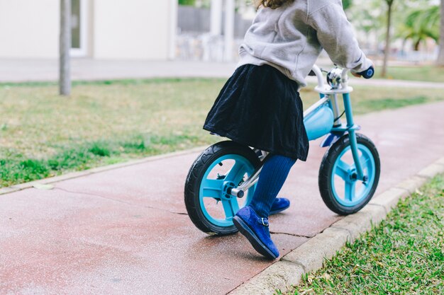 Het meisjes berijdende fiets van het gewas